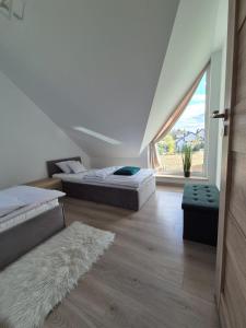 two beds in a room with a large window at Apartamenty Gajewscy in Lipnica Górna +31 photos