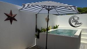 a blue and white umbrella next to a swimming pool at Villa Blue HN in Trujillo