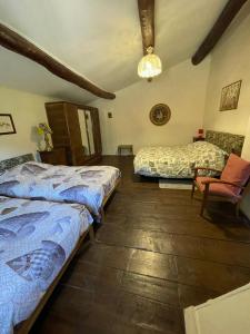 a bedroom with two beds and a chair at SO MAGIC - La casa nel bosco in San Godenzo