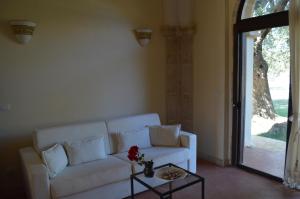 un soggiorno con divano bianco e tavolo di Masseria Le Celline a Nardò