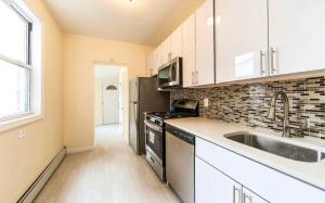 una cucina con mobili bianchi e un lavandino di Stunning, Spacious House in Brooklyn, NYC! a Brooklyn