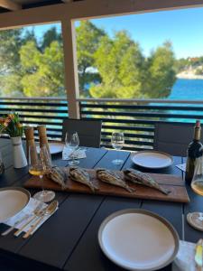 a table with glasses of wine and a board with fish at Luxury Seaside Mobile Home DK, Porat Beach in Drage