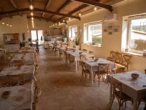 a dining room with tables and chairs and windows at Il poggio degli antichi sapori in Paternopoli
