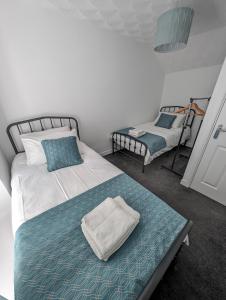 a bedroom with a bed and a bed and a chair at Ty Collective - Near Town Centre in Dowlais