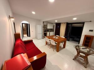 Una sala de estar con un sofá rojo y una mesa. en Paraiso villas, en Playa Paraiso