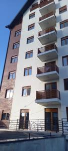 a tall white building with balconies on it at Garfield in Zlatibor