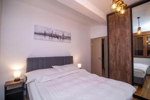 a bedroom with a large bed with white sheets at Garfield in Zlatibor +25 photos