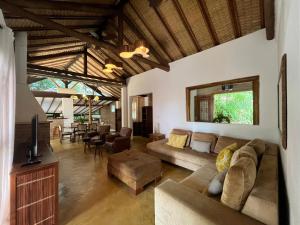 a living room with a couch and a tv at Beira Mar Ilha Guest in Ilhabela