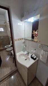 a bathroom with a sink and a mirror at Apartamentos Marconi in Resistencia