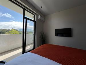 a bedroom with a bed and a large window at Dreamside Apartment in Chakvi