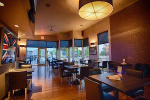 a restaurant with tables and chairs and windows at Z Loft Extended Stay Hotel in Saint Robert