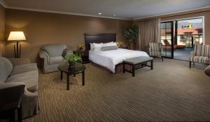 a hotel room with a bed and a living room at Coast Anabelle Hotel in Burbank