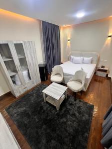 een slaapkamer met een bed en 2 stoelen en een tafel bij Triple garden view hotel in Caïro