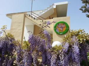 un edificio con flores púrpuras delante de él en Gongis Studios, en Agios Georgios