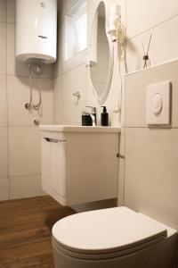 a white bathroom with a toilet and a sink at Iris Apartments in Ohrid