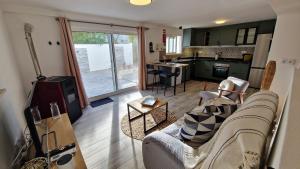 Una sala de estar con un sofá y una cocina. en PoolHouse EstrelasDourada ALVOR, en Alvor