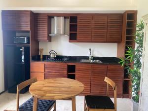サントドミンゴにあるBoutique Hotel Casa Grande, Divas Suiteのキッチン(木製キャビネット、木製テーブル、椅子付)