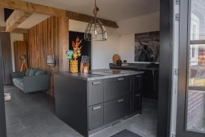a kitchen with a black island in a room at Huisje over de IJssel in Zwolle