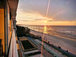 a view of the beach at sunset from a building at RJ Apartament Baltic Infinity Resort & Spa - free parking in Międzyzdroje