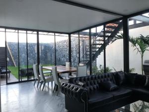 a living room with a black couch and a table at Hermosa casa vista al lago in Tequesquitengo