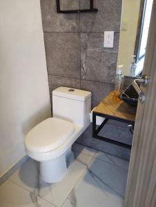 a bathroom with a white toilet and a wooden table at Hermosa casa vista al lago in Tequesquitengo