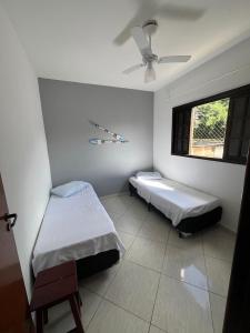 a bedroom with two beds and a window at Apto bem equipado, com 2 quartos acomoda até 6 pessoas confortavelmente in Ubatuba