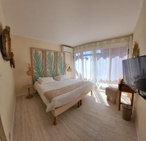 a bedroom with a bed and a flat screen tv at Hotel Tennis International in Cap d'Agde +69 photos
