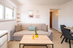 a living room with a couch and a table at Aeolos Loft - 3 min Walk to Beach & Town in Kos