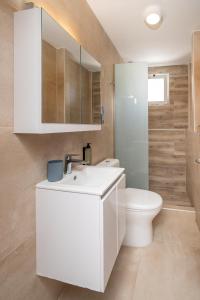 a bathroom with a white sink and a toilet at Aeolos Loft - 3 min Walk to Beach & Town in Kos