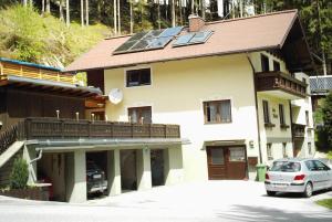 ein Haus mit einem Solardach mit einem Auto vor dem Haus in der Unterkunft My Appartement - Haus Waldeck in Schladming