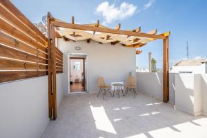 a patio with a wooden pergola and chairs at Aeolos Loft - 3 min Walk to Beach & Town in Kos +30 photos