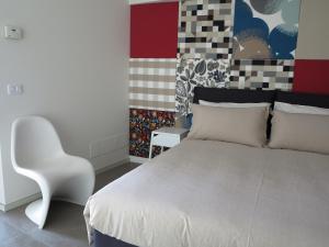 a bedroom with a white bed and a white chair at Residence "I Centralissimi Mamiblu' " in Vasto