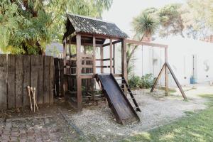 a playground with a slide and a wooden structure at Miraverde in Pinamar