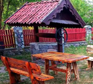 a picnic table and a bench in front of a building at Sielski Zakątek in Srokowo
