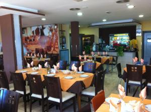 un ristorante con tavoli e sedie con tovaglioli sopra di Hotel El Cruce a Moraleda de Zafayona