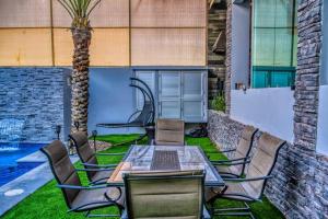 Un patio con mesa y sillas y una palmera. en Unique FAMILY CAVE Heated Pool on demand, en Puerto Peñasco