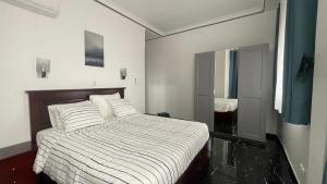 a bedroom with a bed with white blankets and pillows at Résidence Belle Alliance in Yaoundé +26 photos