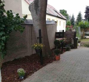 una croce accanto a un albero accanto a una casa di Modern & Comfortable Apartments in Central Altenburg ad Altenburg