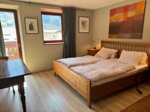 a bedroom with a bed and a table and windows at House Maharac With 3 Apartments Till 18 Persons in Kamno