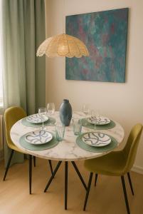 a dining room table with plates and wine glasses at Design Apartment mit Parkplatz - 15 min Flughafen in Offenbach +7 photos