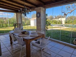 ein Esszimmer mit Tisch und Stühlen und großen Fenstern in der Unterkunft Villa Erika, Landidyll bei Ostuni in San Vito dei Normanni