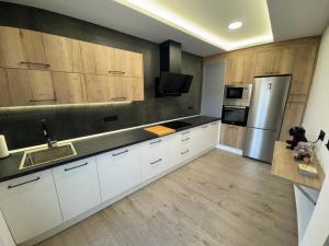 a kitchen with white cabinets and a stainless steel refrigerator at Callejón de Chirinos in Úbeda