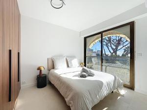 a bedroom with a large bed with a large window at 2 pièces vue mer, piscine, à 2 pas des plages in Cannes +8 photos