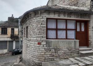 a brick house with a window on the side of it at Suite of Bazaar in Gjirokastër