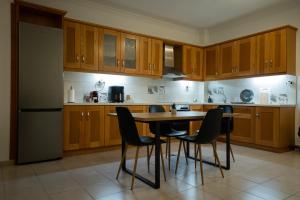 a kitchen with wooden cabinets and a table and chairs at Spacious home in Klitoria