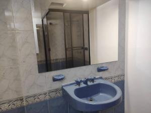 a bathroom with a blue sink and a mirror at Habitación 4 independiente con baño privado Unicentro in Bogotá