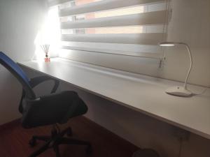 a desk with a chair and a lamp and a window at Habitación 4 independiente con baño privado Unicentro in Bogotá +3 photos