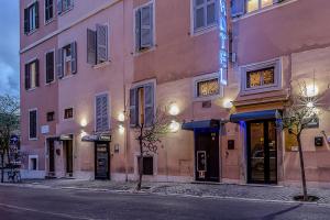 un bâtiment rose dans une rue d'une ville dans l'établissement Hotel Center 3, à Rome