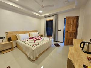 a bedroom with a bed with red flowers on it at Sunset Beach View in Dhangethi