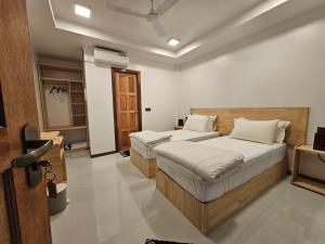 a bedroom with two beds and a television in it at Sunset Beach View in Dhangethi